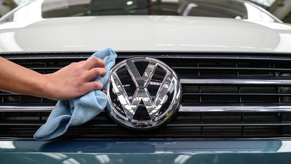 Pracownik czyści logo Volkswagena T6 z pojazdów użytkowych Volkswagen na linii kontroli końcowej w fabryce Volkswagena pojazdów użytkowych w Hanowerze.  © Alliance image / Niemiecka Agencja Prasowa |  Christophe Gatto Zdjęcie: Christophe Gatto