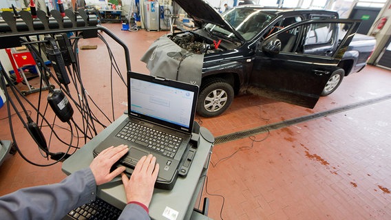 Ein Kfz-Meister lädt im Rahmen der Rückrufaktion zum Abgasskandal ein Software-Update auf einen Volkswagen Amarok mit einem 2,0-Liter-Dieselmotor in einer Volkswagen-Werkstatt in der Region Hannover. © dpa - Bildfunk Foto: Julian Stratenschulte