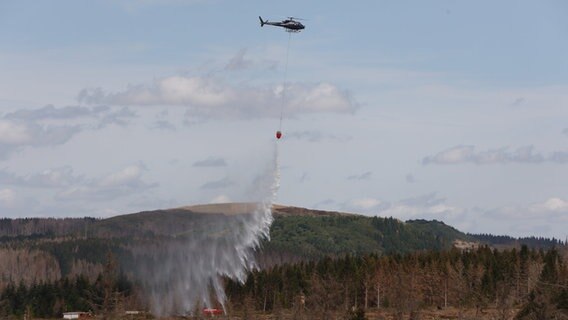 Ein Hubschrauber gibt Löschwasser aus der Luft ab. © dpa-Bildfunk Foto: Matthias Bein