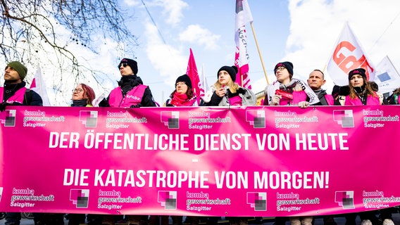 Anhänger verschiedener Gewerkschaften nehmen an einer Protestkundgebung auf dem Ernst-August-Platz teil - der Schriftzug «Der öffentliche Dienst von heute - die Katastrophe von morgen!» ist dabei auf einem Transparent zu lesen. Es geht um den Tarifstreit und die Tarifverhandlungen im öffentlichen Dienst. © Moritz Frankenberg/dpa Foto: Moritz Frankenberg