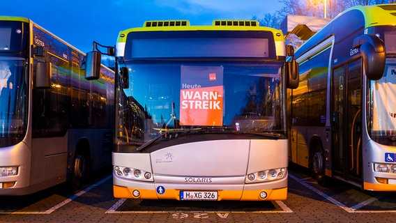 Busse stehen auf einem Betriebshof der hannoverschen Verkehrsbetriebe Üstra - auf einem Plakat ist der Schriftzug "Heute Warnstreik" zu lesen. © picture alliance/dpa Foto: Moritz Frankenberg