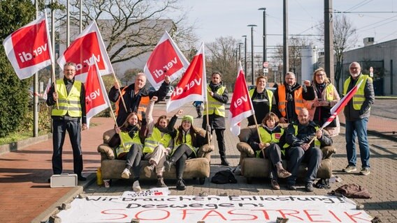 Beschäftigte im öffentlichen Nahverkehr stehen und sitzen auf Sofas vor dem Betriebshof Döhren. © Ole Spata/dpa Foto: Ole Spata