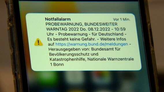 Auf einem Handy-Display ist eine Warnung des Bundesmates für Bevölkerungsschutz zu sehen. © NDR 