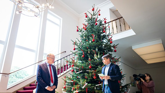 Stephan Weil (SPD, l), Ministerpräsident von Niedersachsen, steht in der Staatskanzlei vor einem Weihnachtsbaum. © dpa-Bildfunk Foto: Moritz frankenberg