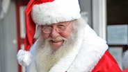 Ein Weihnachtsmann lächelt in die Kamera. © dpa - Bildfunk Foto: Peter Steffen