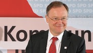 Stephan Weil (SPD) lächelt bei einer Pressekonferenz. © dpa Foto: Peter Steffen