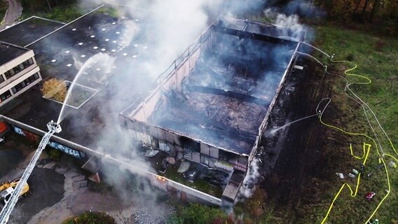 Einsatzkräfte der Feuerwehr bei Löscharbeiten an der brennenden Turnhalle (Luftaufnahme mit einer Drohne) © dpa-Bildfunk 