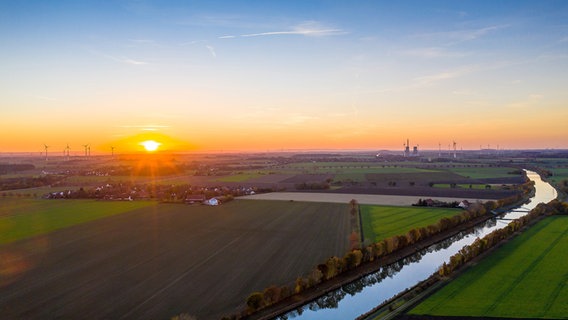 Sonnenuntergang über dem Peiner Land mit weitem Blick auf den Mittellandkanal und im Hintergrund auf das Kraftwerk Mehrum an der Grenze zum Landkreis Hannover. © NDR Foto: Ulf Jasmer