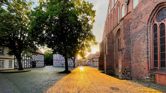 Die Sonne geht hinter einer Kirche in Nienburg unter. © NDR Foto: Tanja Scheer