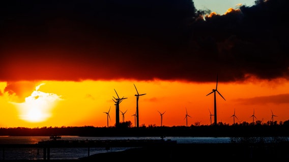 Mehrere Windräder stehen auf einem Feld in Niedersachsen, dunkle Wolken ziehen vorbei. © picture alliance/dpa Foto: picture alliance / Robin Utrecht | Robin Utrecht