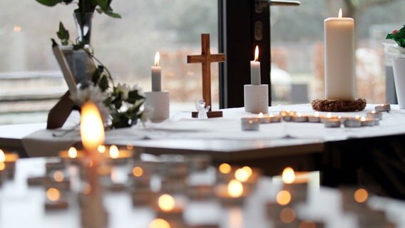 Kerzen und ein Kruzifix stehen im Andachtsraum der IGS Wunstorf. In Wunstorf ist ein 14-Jähriger mutmaßlich getötet worden. © Lothar Veit/Landeskirche Hannover Foto: Lothar Veit