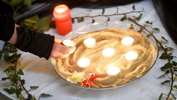 Świece w misce we wnętrzu kościoła Korwina w Wunsdorf.  W Wunstorf zginął 14-letni chłopiec.  © Nancy Heusel/Landeskirch Hannover Zdjęcie: Nancy Heusel/Landeskirch Hannover