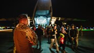 Menschen steigen bei einem Evakuierungseinsatz der Bundeswehr in Jordanien aus einem Transportflugzeug. © Bundeswehr Foto: Neumann