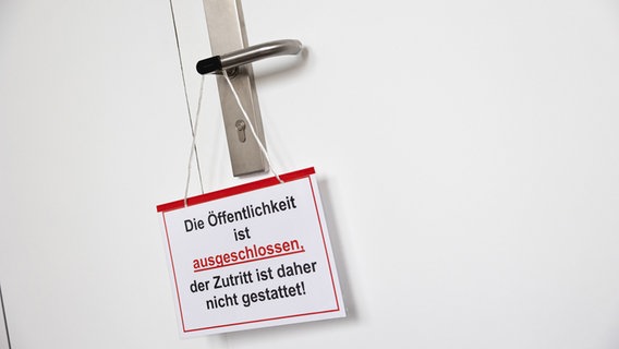 Auf einem Schild beim Auftakt des Mordprozesses Wunstorf steht "Die Öffentlichkeit ist ausgeschlossen". © Michael Matthey/dpa Foto: Michael Matthey/dpa