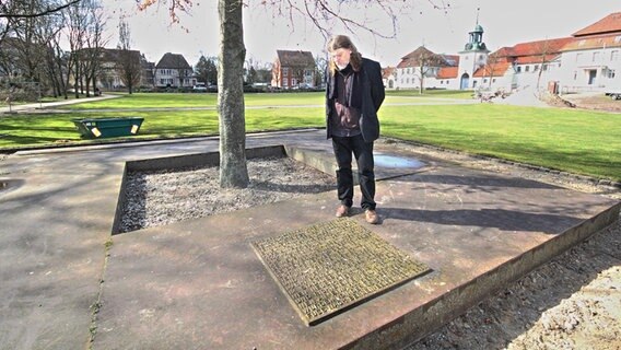 Der Ortshistoriker Reinhard Rohdebetrachtet ein schlichtes Mahnmal in den Celler Triftanlagen in der Nähe des Bahnhofes. Es erinnert an die Hetzjagd auf KZ Häftlinge zum Ende des 2. Weltkrieges. © NDR Foto: Uwe Day