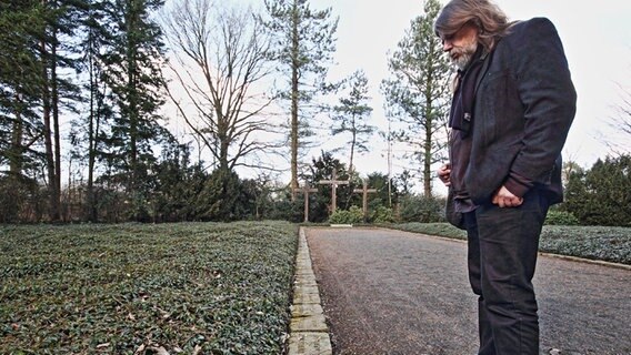 Ortshistoriker Reinhard Rohde betrachtet Bodenplatten. Sie gehören zum Celler Mahnmal an die Hetzjagd auf KZ Häftlinge zum Ende des 2. Weltkrieges. © NDR Foto: Uwe Day