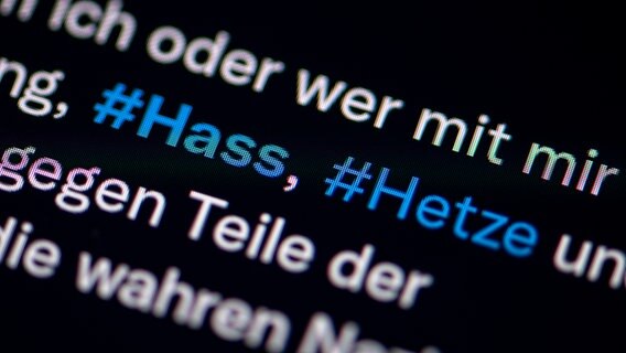Auf dem Bildschirm eines Smartphones sieht man die Hashtags Hass und Hetze in einem Twitter-Post. © picture alliance/dpa Foto: Fabian Sommer
