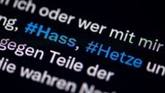 Auf dem Bildschirm eines Smartphones sieht man die Hashtags Hass und Hetze in einem Twitter-Post. © picture alliance/dpa Foto: Fabian Sommer
