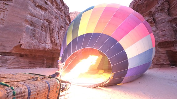 Ein Heißluftballons wird in der Felsenstadt in Jordanien befeuert. © Tobias Landmann Foto: Tobias Landmann