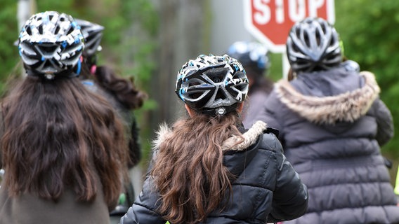 Drei Personen tragen einen Helm und fahren auf einem Fahrrad. © picture alliance / dpa Foto: Jens Kalaene