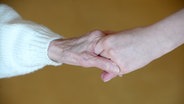 Die Hand einer älteren Person greift nach der jüngeren Hand. © picture alliance / ZB Foto: Peter Endig