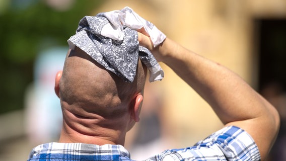 Ein Mann wischt sich bei großer Hitze mit einem Stofftuch über den Kopf. © picture alliance/dpa | Sebastian Kahnert Foto: Sebastian Kahnert