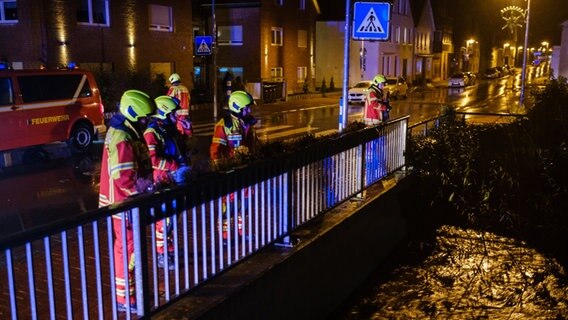 Feuerwehrleute beobachten den Wasserstand der Rodenberger Aue. © dpa Foto: Ole Spata