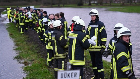 Einsatzkräfte der Feuerwehr und freiwillige Helfer versuchen mit Sandsäcken die Ortschaft Langholt zu sichern, nachdem das Hochwasser vom Burlage-Langholter Tief, einem Nebenfluss der Leda, über die Deiche trat oder sie aufweicht. © dpa Foto: Lars Penning