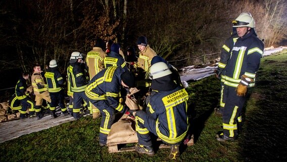 Einsatzkräfte der Feuerwehr sichern den aufgeweichten Deich der Hunte nahe der Ortschaft Astrup mit Vlies und Sandsäcken. © dpa Foto: Hauke-Christian Dittrich