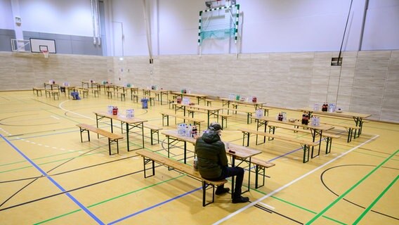 Ein Mann sitzt in Winsen (Aller) in einer Sporthalle, die als Notunterkunft eingerichtet wurde. © dpa Foto: Philipp Schulze