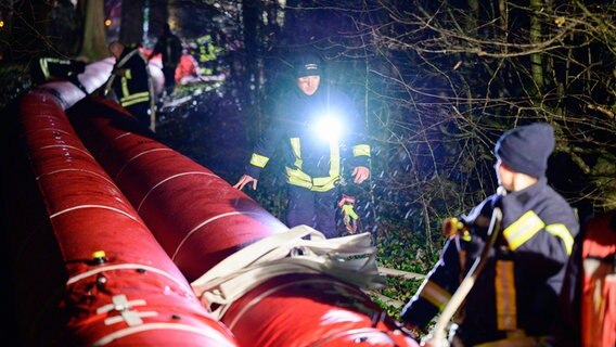 Ehrenamtliche Einsatzkräfte der Feuerwehr bauen in Wienhausen einen Mobildeich auf. © dpa Foto: Philipp Schulze