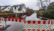 Eine Straße in einem Wohngebiet in Lilienthal steht unter Wasser. © NDR Foto: Sebastian Duden