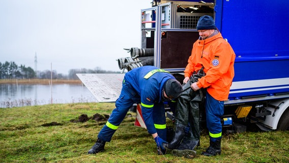Zwei ehrenamtliche Helfer des Technischen Hilfswerks stehen vor einem Einsatzfahrzeug. © dpa Bildfunk Foto: Philipp Schulze