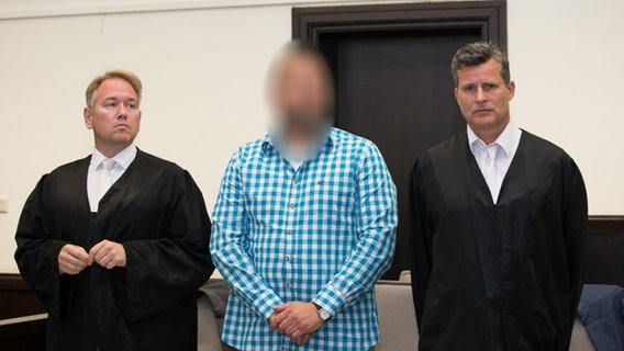 Der Angeklagte Wilfried Max W. (M) steht neben seinen Verteidigern Carsten Ernst (l) und Detlev Binder (r) in einen Saal des Landgerichts.  Foto: Friso Gentsch