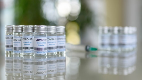 Fläschchen eines COVID-19-Impfstoffs stehen auf einem Glastisch. © picture alliance / Geisler-Fotopress | Dwi Anoraganingrum Foto:  Geisler-Fotopress
