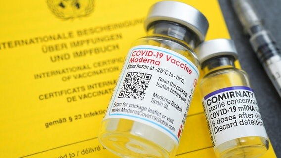Impfausweis mit Impfspritze und Impfstofffläschchen von Biontech und Moderna © picture alliance / CHROMORANGE Foto: Christian Ohde