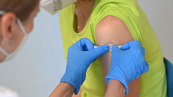 Eine Frau bekommt nach einer Impfung ein Pflaster auf die Einstichstelle. © picture alliance/SvenSimon/Frank Hoermann Foto: Frank Hoermann