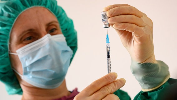 A woman draws up a syringe.  © picture alliance / dpa Photo: Swen Pförtner