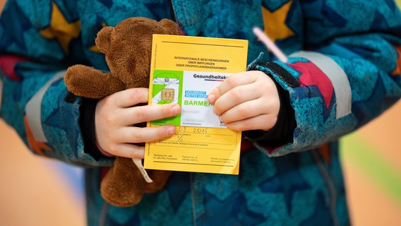 Ein Kind hält einen Impfpass und ein Kuscheltier in der Hand. © picture alliance/dpa | Daniel Reinhardt Foto: Daniel Reinhardt