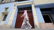 Eine Frau mit Kopftuch läuft an einer Moschee vorbei. © dpa-Bildfunk Foto: Helmut Fohringer