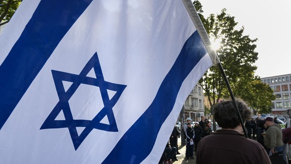 Mężczyzna trzyma izraelską flagę podczas demonstracji.  © Image Alliance/dpa |  Heiko Rebsch Zdjęcie: Heiko Rebsch