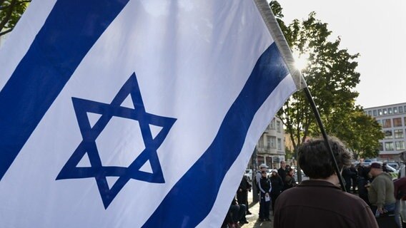 Eine Person hält eine Israel-Flagge auf einer Demonstration. © picture alliance/dpa | Heiko Rebsch Foto: Heiko Rebsch
