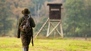 Eine Jägerin geht mit ihrer Bockbüchsflinte zu einem Hochsitz. © dpa Bildfunk Foto: Philipp Schulze