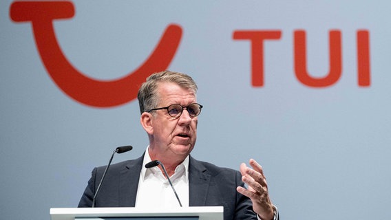 Friedrich Joussen spricht an einem Mikrofon vor einer TUI Logo. © picture alliance/dpa | Peter Steffen Foto: Peter Steffen