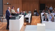 Ministerpräsident Stephan Weil (SPD) steht bei "Jugend debattiert" mit einer jungen Frau auf dem Podium im Landtag. © NDR 