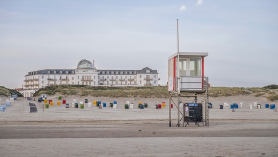 Eine Bademeister-Hütte steht am Strand von Juist vor dem Strandhotel Kurhaus. © picture alliance / Westend61 Foto: Kerstin Bittner