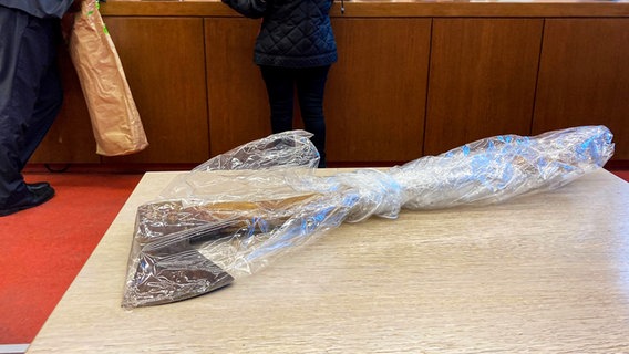 Die Tatwaffe, eine Axt, liegt auf dem Tisch in einem Saal vom Landgericht (beim Prozess zum den sogenannten Axtmörder von Kalletal). © Carsten Linnhoff/dpa Foto: Carsten Linnhoff/dpa
