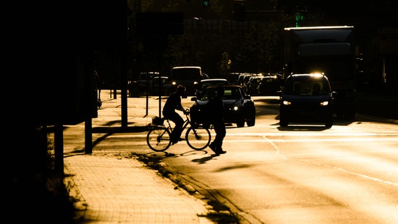 Stadtverkehr im Licht der aufgehenden Sonne. © picture alliance/dpa/Julian Stratenschulte 