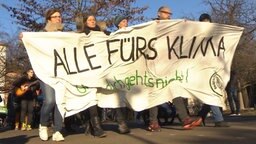 Klimaaktivisten halten ein Banner mit der Aufschrift 