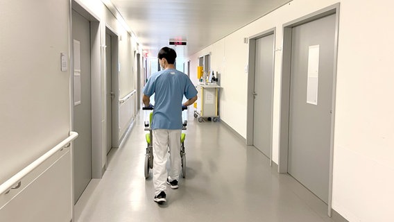 Ein Krankenpfleger schiebt einen Wagen über einen Flur im Krankenhaus Siloah in Hannover. © NDR Foto: Mandy Sarti